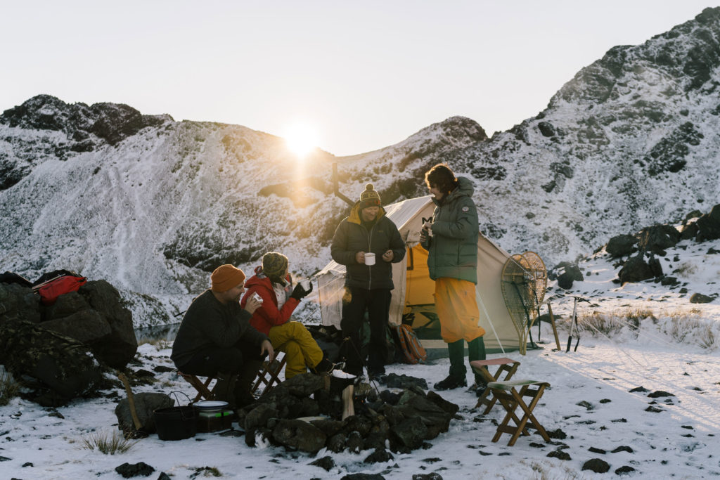Group of peiople having coffee camping in the snow - The Great Glenorchy Alpine Base Camp